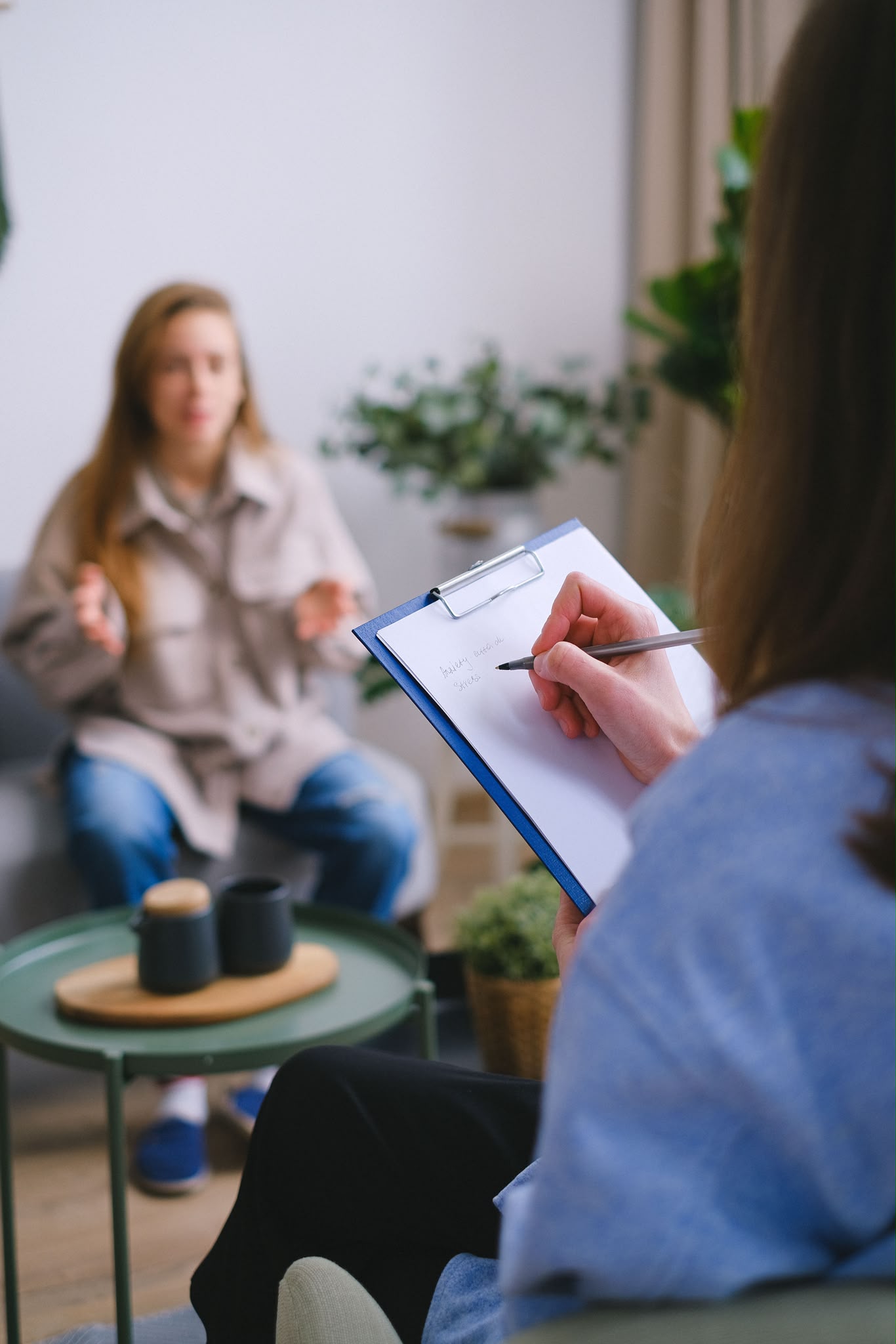 Psycholożka robiąca notatki podczas rozmowy z pacjentką